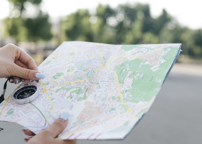 close-up-female-hand-holding-map-navigational-compass